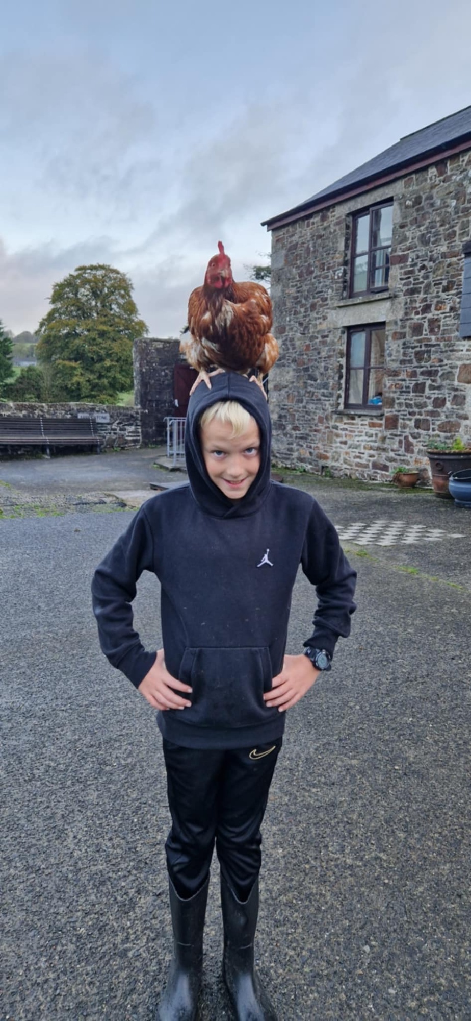 Photo of child with chicken on his head